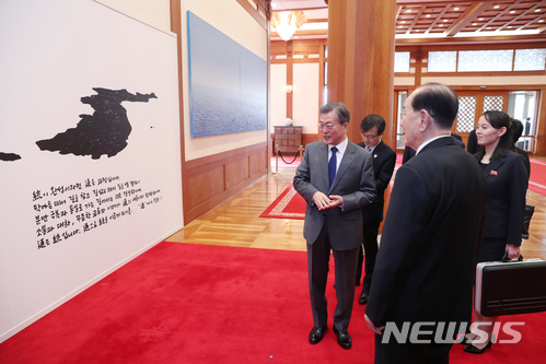 ▲ 문재인 대통령이 지난 2018년 2월10일 청와대 본관 접견실에서 김여정 등 북 고위급 대표단에게 신영복의 글씨와 판화가 이철수 씨의 판화 작품을 합쳐서 만든 서화를 설명하고 있다.ⓒ뉴시스