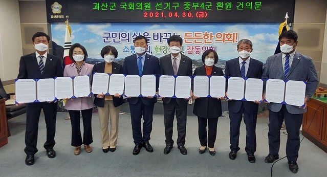 ▲ 괴산군의회 의원들이 30일 본회의장에서 괴산군 국회의원선거구 중부4군 환원 건의문을 채택한 뒤 기념촬영을 하고 있다.ⓒ괴산군의회