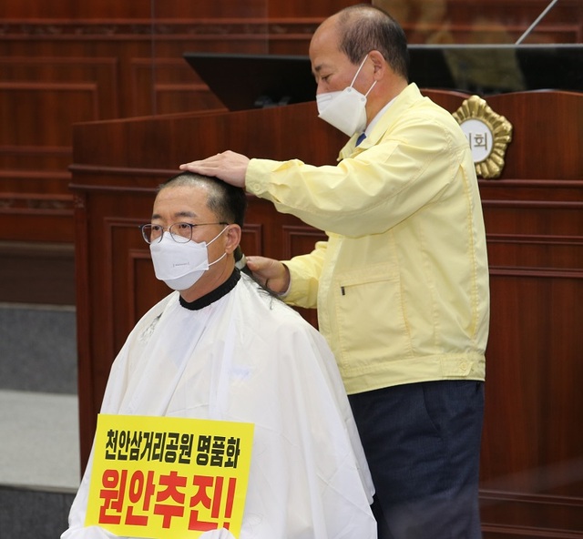 ▲ 천안시의회 이종담 의원이 지난달 30일 본회의장에서 천안삼거리명품화사업 원안 추진을 주장하며 삭발을 하고 있다.ⓒ천안시의회