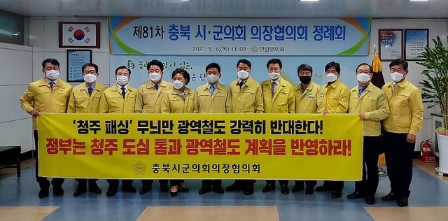 ▲ 충북시·군의회의장협의회는 6일 단양군의회에서 정례회를 열고 4차 국가철도망계획 노선에 청주 도심 통과 반영결의안을 채택했다. 결의안 채택 후 최충진 청주시의회의장 등이 현수막을 들고 청주도심통과 반영을 촉구하고 있다.ⓒ충북시·군의회의장협의회