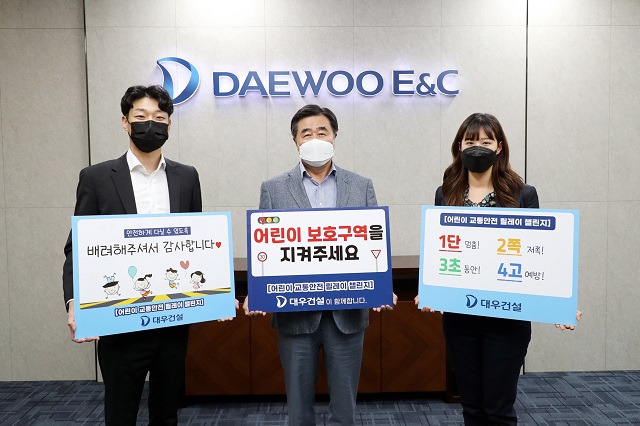 ▲ 김형 대우건설 사장(가운데)이 교통안전표어를 들고 어린이 교통안전 릴레이 챌린지에 참여하고 있다.ⓒ대우건설