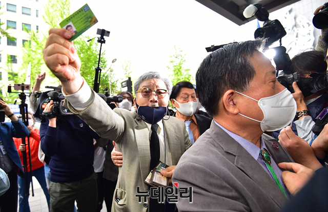 ▲ 김임용 씨가 지난달 23일 서울 여의도 광복회관에서 열린 상벌위원회에 입장하며 경찰에 저지당하자 독립유공자 유족증을 들어보이고 있다. ⓒ정상윤 기자