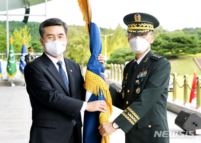 ▲ 남영신 신임 육군참모총장(오른쪽)이 지난해 9월 23일 충남 계룡대에서 열린 제49대 육군참모총장 취임식에서 서욱 국방부 장관에게 육군기를 전달받고 있다.ⓒ뉴시스