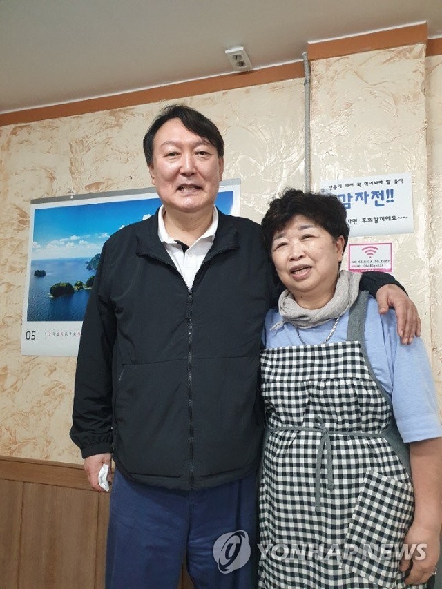 ▲ 윤석열 전 검찰총장이 지난달 29일 강원 강릉시 강릉중앙시장 인근 '감자바우' 식당에서 음식점 사장과 기념사진을 찍고 있다.ⓒ연합뉴스(윤석열 측 제공)