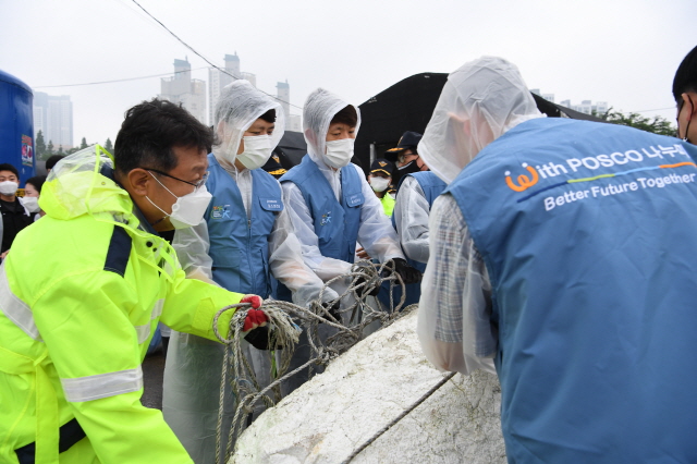 ▲ 한성희 사장을 포함한 임직원들이 소래포구 연안정화활동을 실시하고 있다. ⓒ 포스코건설