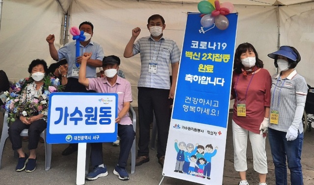 ▲ 대전 서구 가수원동 자원봉사협의회와 적십자회 회원들이 백신 2차 접종이 시작된 지난달 23일부터 ‘접종 완료 인증 사진’을 촬영하는 작은 이벤트를 진행하고 있다.ⓒ대전서구