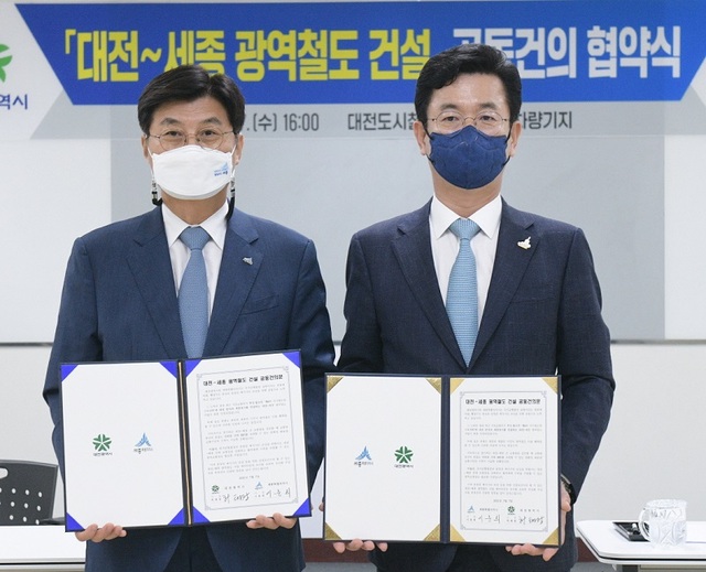 ▲ 이춘희 세종시장(왼쪽)과 허태정 대전시장은 7일 대전 외삼차량기지에서 만나 대전~세종 광역철도 건설사업의 신속한 추진을 위한 공동건의문 서명식을 하고 기념촬영을 하고 있다.ⓒ세종시