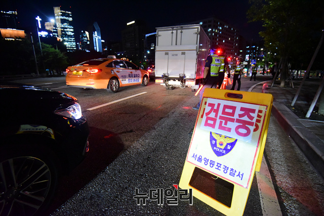 ▲ 코로나19 대응 전국자영업자비상대책위원회의 거리두기 4단계 조치 항의 심야 차량 시위가 예정된 14일 밤 국회 앞에서 경찰이 차량에 대한 검문을 하고 있다. ⓒ이종현 기자