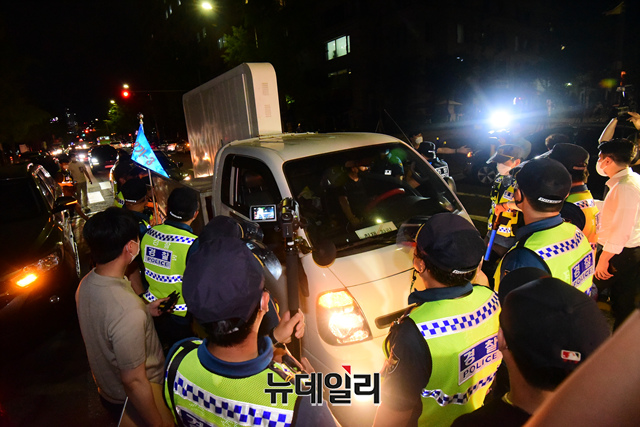 ▲ 코로나19 대응 전국자영업자비상대책위원회의 거리두기 4단계 조치 항의 심야 차량 시위 참가자가 14일 밤 서울 여의도공원 앞에서 경찰의 저지를 받고 있다. ⓒ이종현 기자