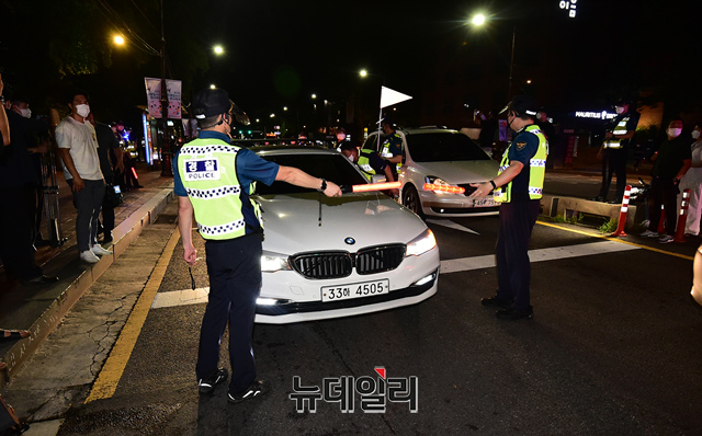 ▲ 14일 밤 서울 종로구 혜화역 인근에서 전국자영업자비상대책위원회의 거리두기 4단계 조치에 항의하며 차량 시위를 이어가자 경찰들이 차량을 통제하고 있다. ⓒ이종현 기자