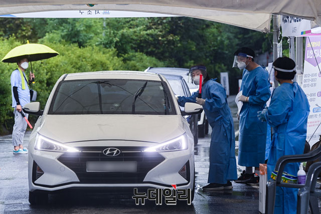▲ 19일 오후 서울 서초구 심산기념문화센터에 마련된 드라이브스루 선별검사소에서 의료진들이 차량을 타고 온 시민들의 검체 체취를 하고 있다. ⓒ강민석 기자