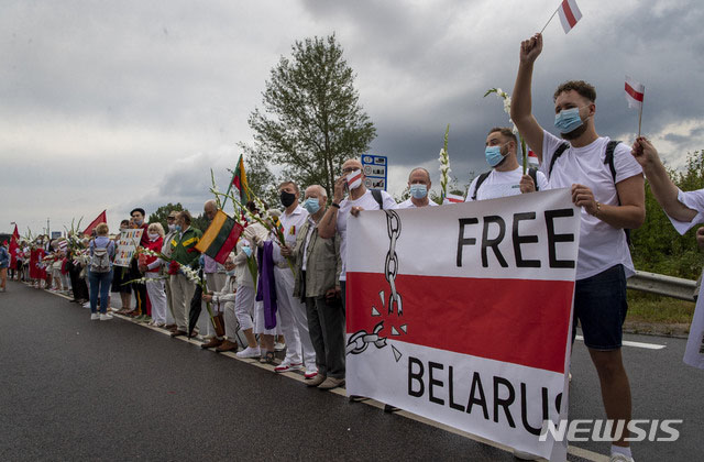 지난해 8월 리투아니아-벨라루스 접경지역에 모여 벨라루스 독재정권을 규탄하는 리투아니아 시민들. 리투아니아 시민들은 소련 통치 경험 때문에 공산주의 체제나 독재체제를 대단히 싫어한다. ⓒ뉴시스 AP. 무단전재 및 재배포 금지.
