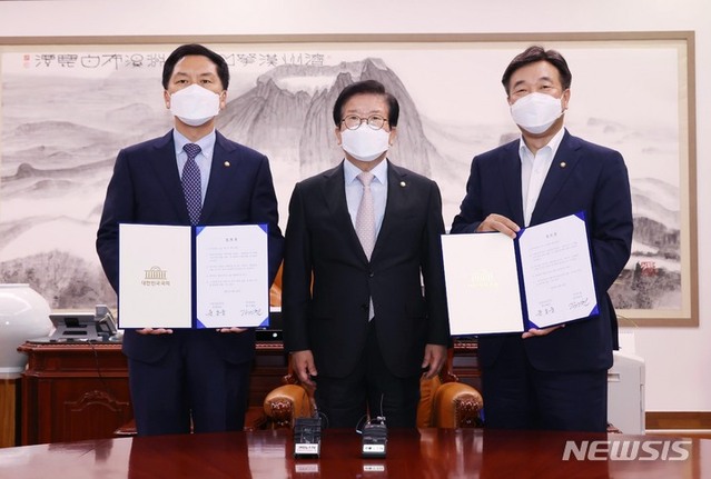 ▲ 윤호중 더불어민주당 원내대표(오른쪽), 김기현 국민의힘 원내대표(왼쪽)가 31일 서울 여의도 국회에서 언론중재법 개정안 처리 협의체 구성 등의 내용이 담긴 합의문을 들고 기념촬영을 하고 있다. 가운데는 박병석 국회의장. ⓒ뉴시스