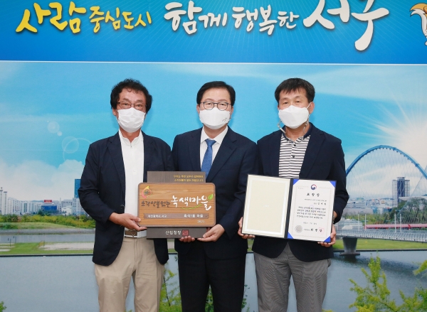 ▲ 장종태 서구청장이 지난 30일 흑석 1통 김재원 통장에게 산림청장 표창장과 선정 기념현판을 전수했다.ⓒ대전 서구