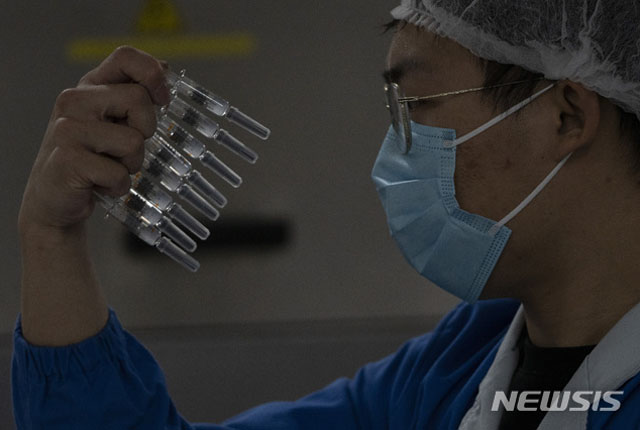 ▲ 시노백 백신을 들어 살펴보는 중국 방역관계자. 중국산 코로나 백신은 현재 코백스를 통해 전 세계에 유통되고 있다. ⓒ뉴시스 AP. 무단전재 및 재배포 금지.