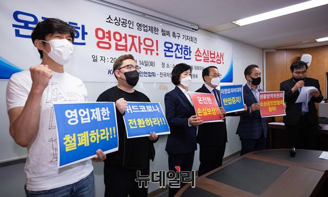 ▲ 오세희 소상공인연합회 회장(왼쪽 세 번째)을 비롯한 참석자들이 14일 오전 서울 여의도 소상공인엽합회에서 영업제한 폐지 및 완전한 손실보상을 촉구하는 기자회견을 하고 있다. ⓒ강민석 기자