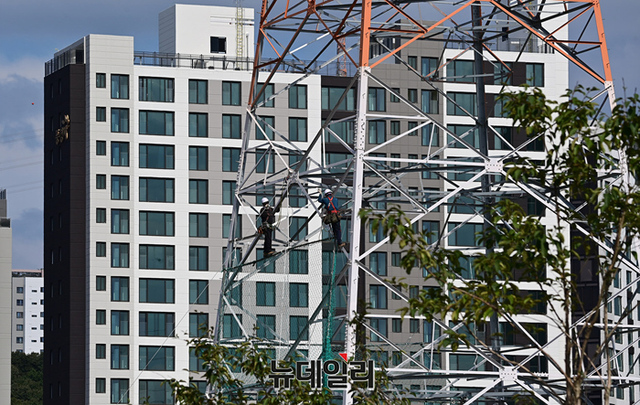 ▲ 지난 26일 대장지구 내 아파트 인근에 설치된 송전탑에서 인부들이 작업을 하고 있다. ⓒ정상윤 기자