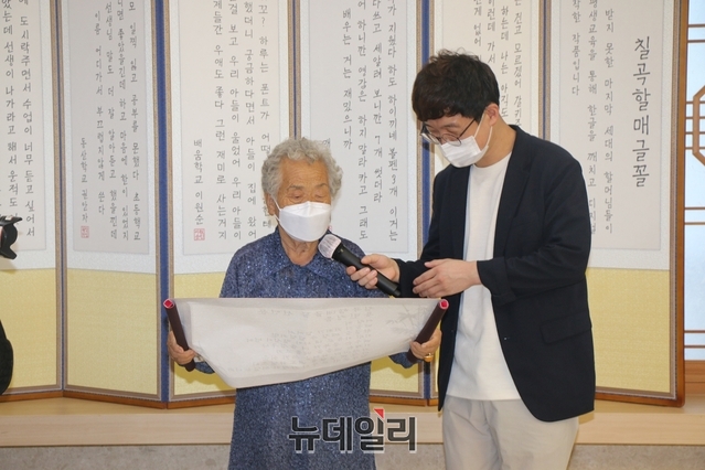 ▲ 칠곡할매글꼴을 제작한 추유을(87) 할머니가 용민정음을 읽고 있다.ⓒ뉴데일리