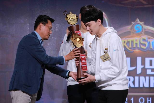 ▲ 지난 16일 서울 강남구 VSG 아레나에서 개최한 ‘2021 오로나민C 하스스톤 히어로즈 챔피언십’ 결승전에서 조익성 동아오츠카 대표이사(왼쪽)가 1위 팀 숭실대 '혈석찬 손커스'팀에게 우승 트로피를 수여하고 있다. ⓒ동아오츠카