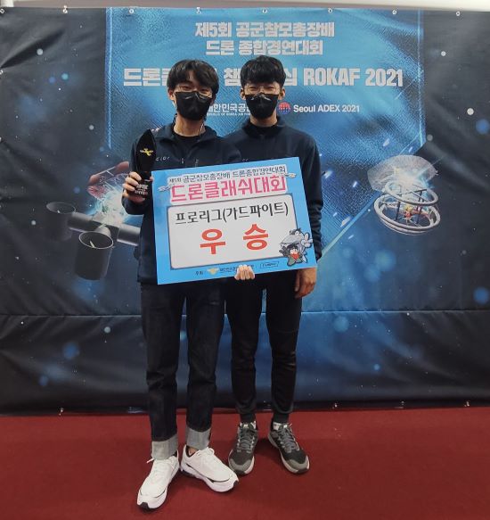 ▲ 청주대학교 무인항공기학전공 전제형(왼쪽) 학생이 제5회 공군참모총장배 드론 클래쉬 챔피언십 대회(ROKAF 2021) 프로리그 가드파이트 부문 우승을 차지한 후 기념촬영을 하고 있다.ⓒ청주대