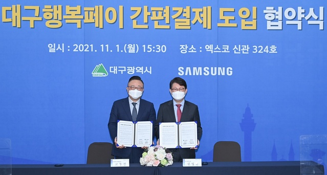 ▲ 권영진 대구시장(오른쪽)과 고동진 삼성전자(주) 대표이사는 지난 1일 엑스코에서 ‘대구행복페이 간편결제 서비스 도입을 위한 업무협약’을 체결했다.ⓒ대구시