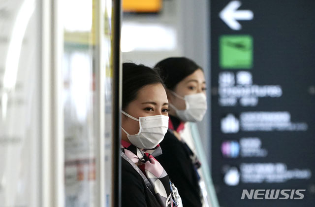 ▲ 일본 도쿄 하네다 공항에서 마스크를 쓴 채 일하는 승무원들. ⓒ뉴시스 AP. 무단전재 및 재배포 금지.