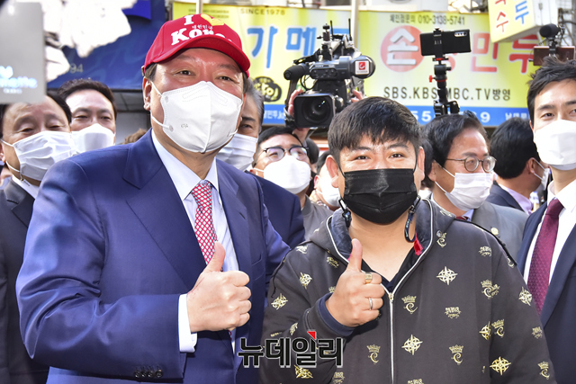 ▲ 윤석열 국민의힘 대선 예비후보가 3일 오전 서울 중구 남대문시장 상점을 방문해 모자를 구매하고 있다.ⓒ강민석 기자