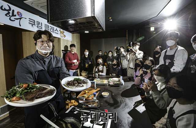 ▲ 한우명예홍보대사 오세득 셰프(왼쪽)가 18일 오후 서울 용산구 한남동 라퀴진에서 진행된 소띠 끼리, 확~ 차이나는 한우 쿠킹 클래스에서 참가자들에게 완성된 한우 티본 스테이크 요리를 선보이고 있다. ⓒ전국한우협회