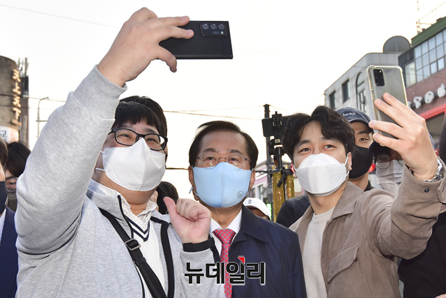 ▲ 홍준표 국민의힘 의원이 지난 4일 서울 마포구 홍대거리를 방문해 청년들과 기념촬영을 하고 있다.ⓒ강민석 기자