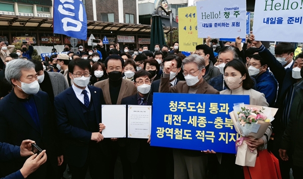 ▲ 21일 층북 청주 육거리종합시장을 방문한 이재명 더불어민주당 대선후보와 부인 김혜경씨가 충청권 광역철도망의 청주도심 통과 노선을 지지한다는 알림판을 들고 있다.ⓒ사진 충청타임즈