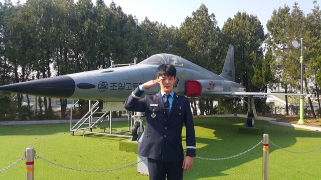 ▲ 공군부사관 임관된 학생이 조일교 교내에 설치된 F-5 전투기에 앞에서 경례를 하고 있다.ⓒ조일고