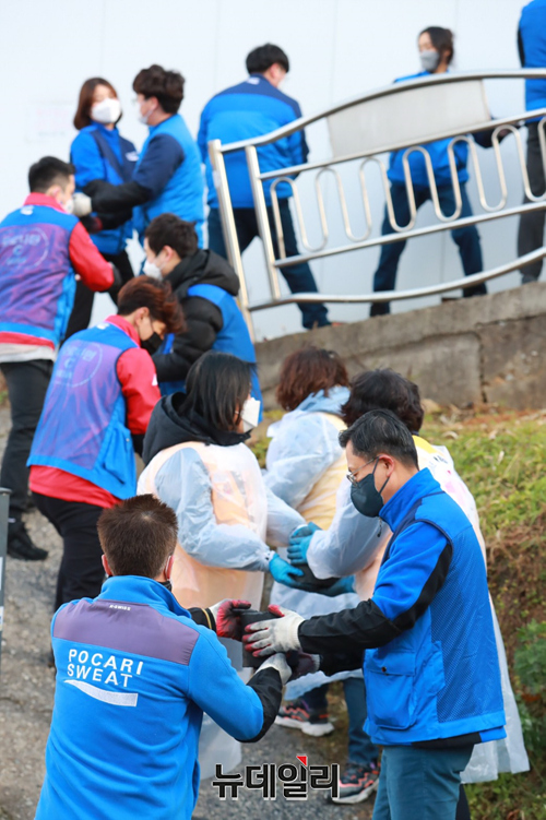 ▲ 동아오츠카가 23일 경기 안양시 만안구 일대에서 열린 '사랑의 이온데이' 봉사활동에서 임직원과 자원봉사자들이 기념촬영을 하고 있다. 봉사활동은 △하천 정화 △어린이 교통안전 △4천장의 연탄 기부 △쌀과 자사제품인 포카리스웨트와 오로나민C 기부 등을 이웃들에게 나눔을 실천했다. ⓒ동아오츠카