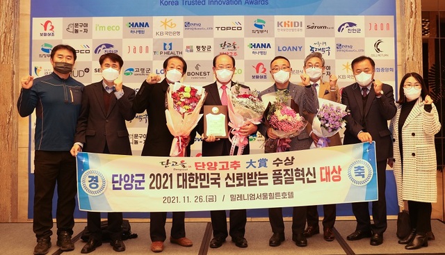 ▲ 류한우 단양군수(왼쪽에서부터 4번째)가 지난 26일 밀레니엄서울힐튼호텔에서 열린 ‘2021 대한민국 신뢰받는 품질혁신 대상’에서 단고을 단양고추가 지역특산물 고추 부문 3년 연속 품질혁신 대상을 받은 뒤 군민들과 함께 기념촬영을 하고 있다.ⓒ단양군