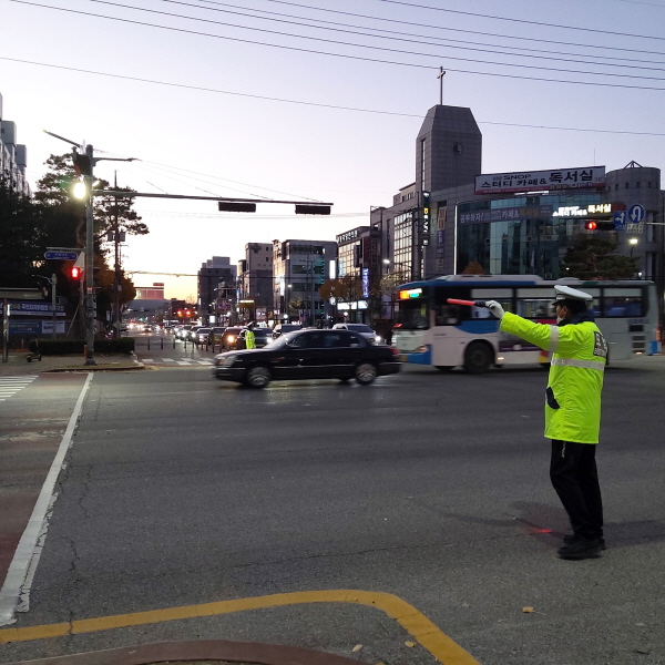 ▲ 충주시모범운전자회 회원이 임광아파트앞 교차로에서 수신호로 차량을 유도하고 있다.ⓒ충주시