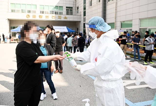 ▲ 조병옥 음성군수가 금왕읍 선별진료소에서 외국인의 손에 소독제를 뿌려주는 봉사를 하고 있다.ⓒ음성군