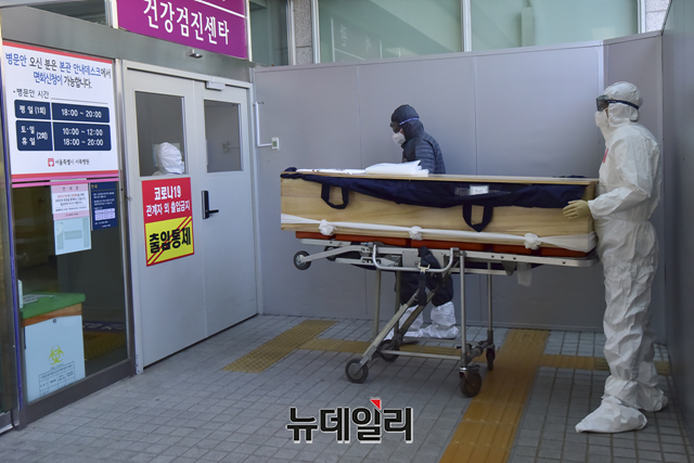 ▲ 지난 3일 오후 서울 은평구 서북병원에서 장례지도사들이 코로나로 숨진 고인의 입관을 위해 격리실로 이동하고 있다. ⓒ강민석 기자