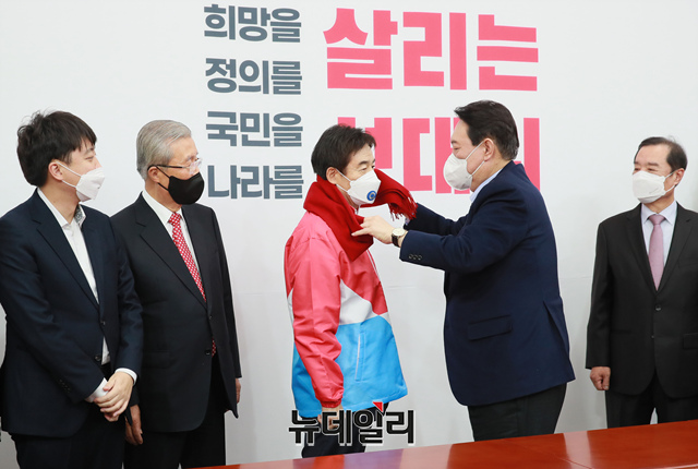 ▲ 윤석열 국민의힘 대선후보가 7일 오후 서울 여의도 국회에서 국민의힘에 입당한 이용호 의원에게 빨간 목도리를 둘러주고 있다.ⓒ뉴데일리(사진=공동취재단)
