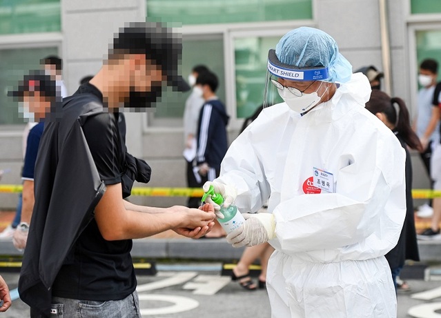 ▲ 조병옥 음성군수가 금왕선별진료소에서 외국인의 손에 소독제를 뿌려주고 있다.ⓒ음성군