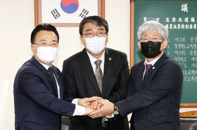 ▲ 서승우(왼쪽) 행정부지사, 서동학 예결특위 위원장, 김성근 부교육감이 14일 충북도의회 제395회 정례회 제7차 예산결산특별위원회에서 손을 맞잡고 있다.ⓒ충북도의회