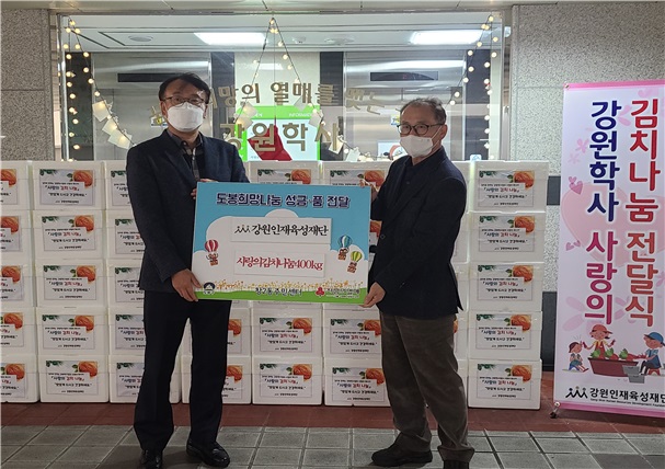 ▲ 강원인재육성 이수종 국장이 지난 20일 김동현 창2동 주민센터장에게 김치를 전달하고 있다.ⓒ강원도