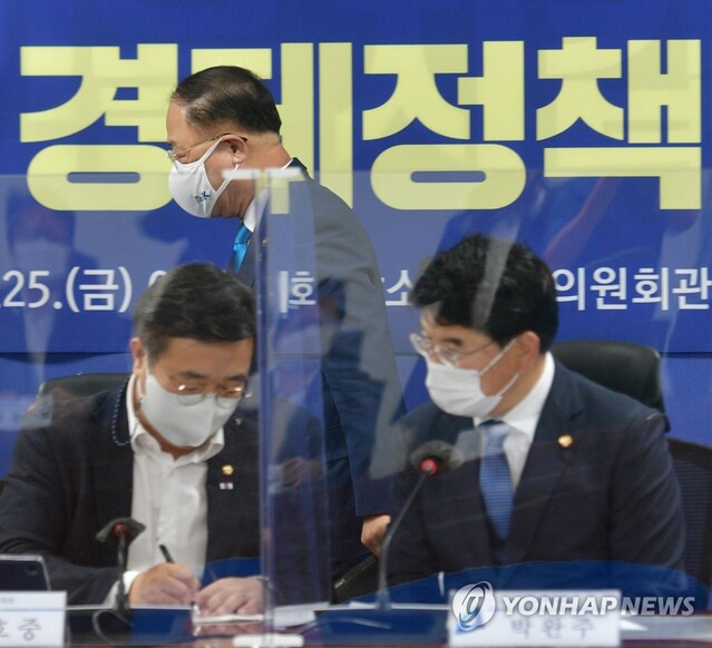 ▲ 지난 6월 국회에서 열린 2021 하반기 경제정책방향 당정협의에 참석하는 홍남기 경제부총리(가운데)와 뭔가를 논의 중인 윤호중 민주당 원내대표(왼쪽)와 박완주 정책위의장.ⓒ연합뉴스