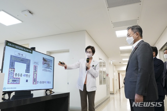 ▲ 문재인 대통령이 24일 서울 강서구 마곡동 이화여자대학교 의과대학 부속 서울병원을 방문, 이선영 이화의료원 전략기획본부장으로부터 병상확충 관련 브리핑을 받고 있다. ⓒ뉴시스