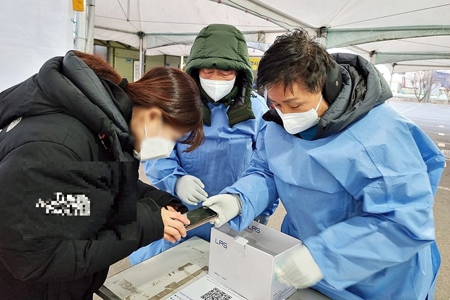 ▲ 충북 청주시의회 최충진 의장등이 성탄절인 지난 25일 청주 상당보건소 선별진료소에서 코로나19 PCR 검사로 격무에 시달리는 직원들을 격려하고 검사 대기자를 대상으로 전자문진표 작성을 안내하는 등 봉사활동을 실시했다. ⓒ청주시의회