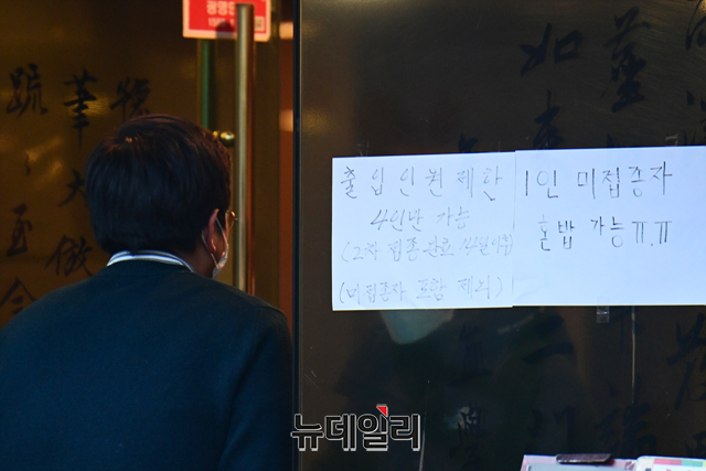지난 달 31일 오후 서울도심 한 식당가 출입문에 출입인원 제한을 알리는 안내문구가 부착돼 있다. ⓒ강민석 기자
