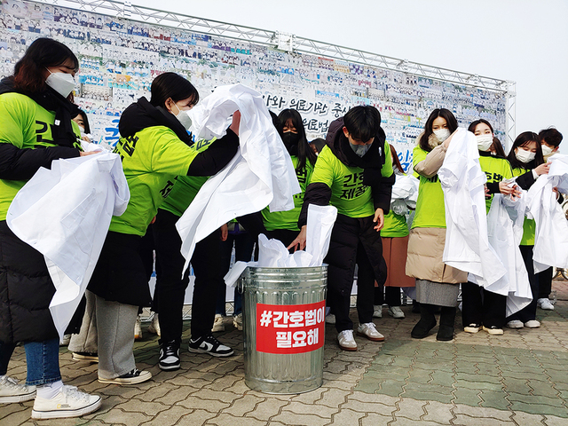 ▲ 전국 시도 간호대생 대표들이 간호사 실습가운을 휴지통에 버리는 퍼포먼스를 하고 있다. ⓒ대한간호협회