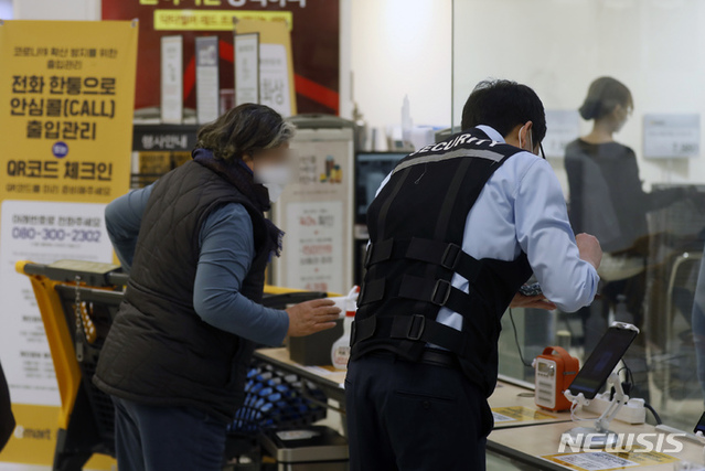 ▲ 17일 서울의 한 대형마트 입구에서 보안직원이 어르신에게 QR코드 등 출입절차를 설명하고 있다. ⓒ뉴시스