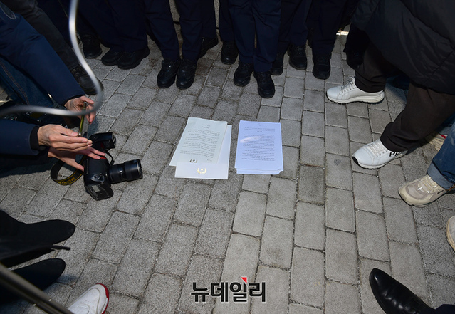 이씨 유족들이 기자회견 직후 문 대통령의 편지를 반환하기 위해 청와대로 향하다 경찰의 저지로 무산되자 편지를 바닥에 내려놓은 모습이다. ⓒ정상윤 기자