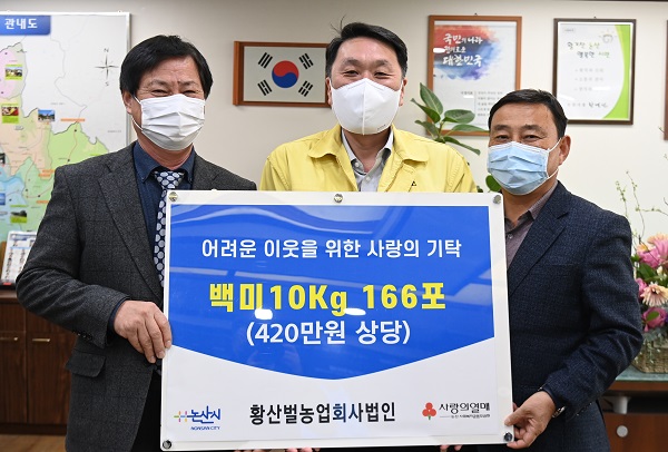 ▲ 이영흠 황산벌 농업회사법인 대표가 지난 20일 논산시청을 방문해 어려운 이웃에게 전달해 달라며 백미 10kg 166포(420만 원 상당)를 안호(가운데) 시장권한대행에게 기부하고 기념촬영을 하고 있다.ⓒ논산시