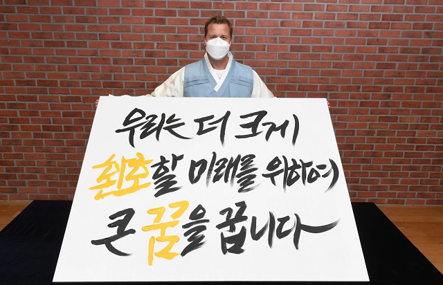 ▲ 오비맥주 배하준 대표가 새로운 기업 슬로건을 공개하는 선포식에서 새 슬로건 캘리그래피 작품을 들고 기념 촬영을 하고 있다.ⓒ오비맥주