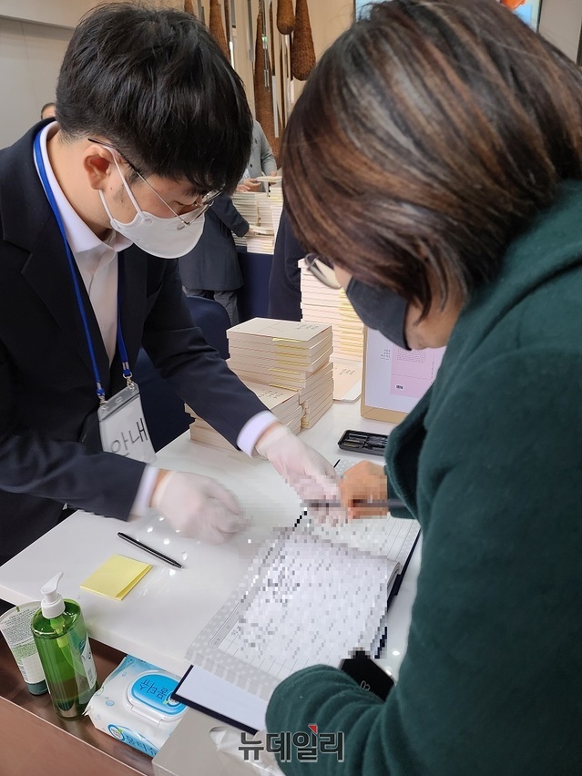▲ 지난 5일 충남 아산에서 열린 김지철 충남교육감 출판기념회에서 한 여성이 방명록에 서명을 하고 있다.ⓒ뉴데일리 D/B